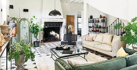 The living room has the charm of a winter garden, with its plants and large French windows opening onto the park. The original floor, too damaged to be preserved, has been replaced by black and white checkerboard tiling. The furniture with elegant lines complements the chic and timeless décor.