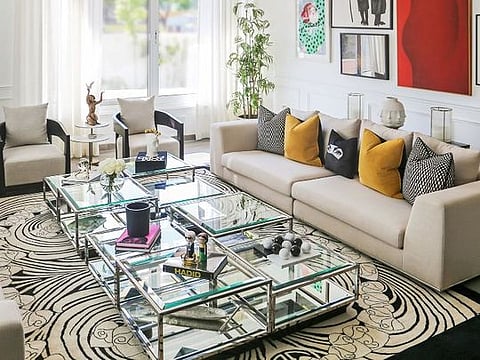 In the living room, the patterned rug from Abbas Carpets, based in Lahore, complements the artistic nature of the scheme. The sofas and armchairs were custom-made while the centrepiece is a selection of eight Eichholtz coffee tables grouped together; accessories are from Jimmie Martin, Jonathan Adler and The One