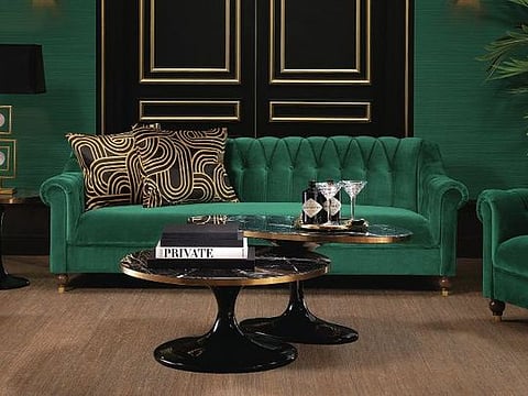Go bold with monochromatic layers of Hunter Green, seen here grounded by a luxurious Eichholtz sofa