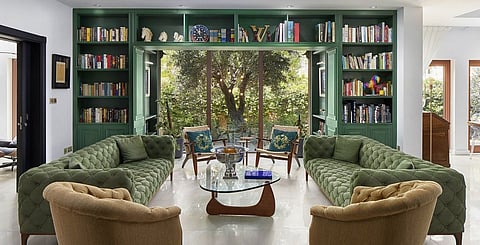 A welcoming, light-filled living room features the library Alessandra always wanted. Paint by Jotun, sofas, coffee table and wood framed chairs from Ebarza. Armchairs from THE One Fusion, reupholstered in yellow fabric.  