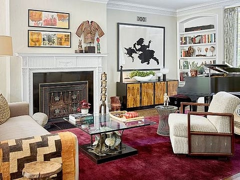 The living room’s eclectic mix of furnishings includes a velvet Donghia sofa and a 1970s Brutalist table by Silas Seandel. Kara Walker’s artwork The Keys to the Coop hangs above the mid-century rosewood burl credenza on the 1920s Chinese Deco rug.