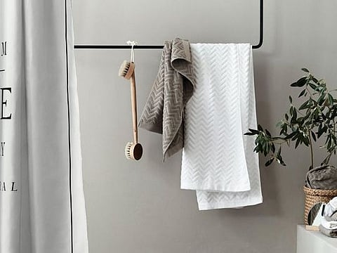 Bathroom accessories all from H&amp;M Home; wooden tray, Dh29; towels from Dh29.