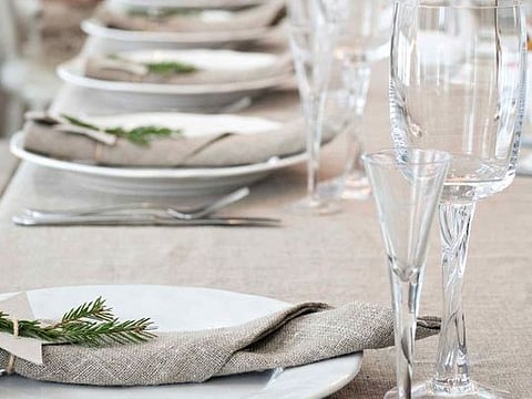 Good-quality plain linen is a worthwhile investment, acting as a backdrop to all kinds of party themes, be it undeniably rustic, bright and festive, or more formal. Here it successfully unites sparkling glass and an ornate candelabra, with sprigs of fresh herbs and greenery. Source: Living4Media