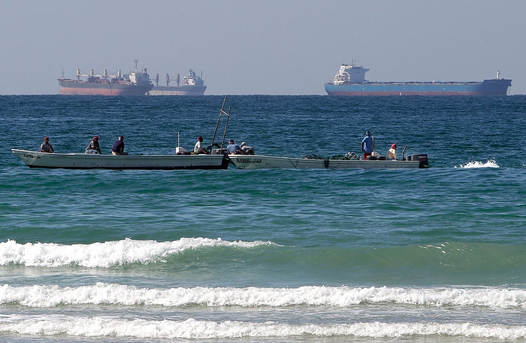 Fishermen work in front of oil tankers south of the Strait of Hormuz Jan. 19, 2012, offshore the town of Ras Al Khaimah in United Arab Emirates. (AP Photo/Kamran Jebreili, File)