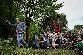 Explosions, red flags: Chinese tourists reenact communist victory