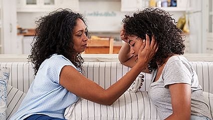 a woman consoling a teen