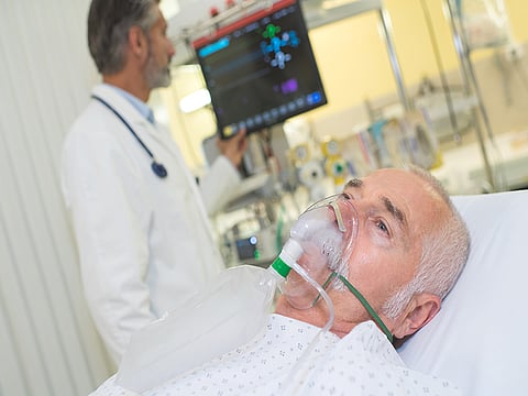 doctor examining his patient wearing oxygen mask