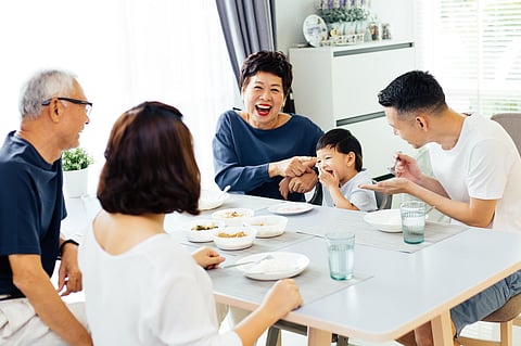 Happy Asian extended family having dinner at home full of laughter and happiness