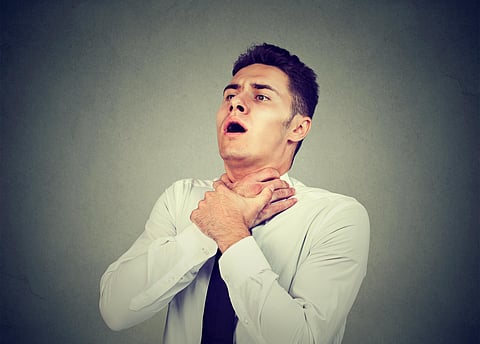 Young man having asthma attack or choking can't breath suffering from respiration problems