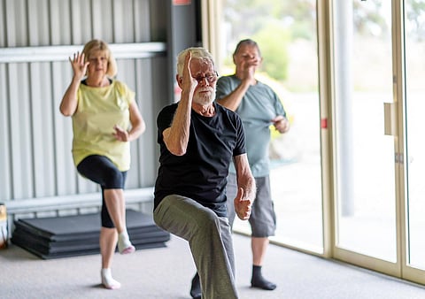 Grupo de personas mayores en la clase de Tai Chi haciendo ejercicio en un estilo de vida de jubilación activo. Beneficios para la salud mental y física del ejercicio y el estado físico en personas mayores. Concepto de atención médica y bienestar para personas mayores.