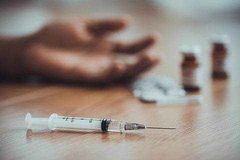 Drug overdose and substance abuse, addiction,addict hand and used drug syringe.