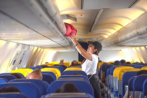woman passenger traveler on boarding aircraft looking for empty overhead locker for luggage keep in safe on the flight