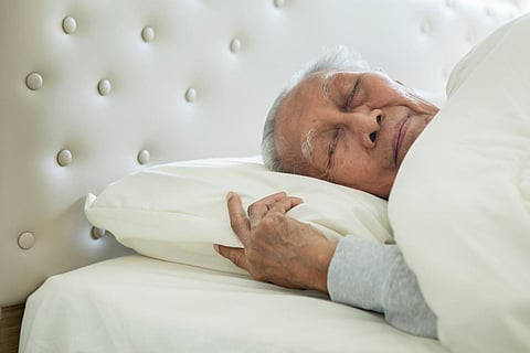 Picture of senior man sleeping with a blanket on the bed. Shot in the bedroom