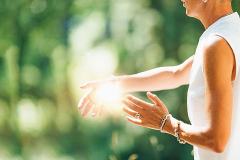 Tai Chi en la naturaleza. Mujer madura practicando Tai Chi en la naturaleza, Primer plano en las manos