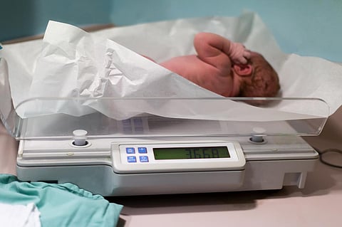 Newborn baby been examined on the balance immediately after childbirth.