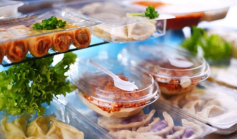 A variety of prepackaged food products in plastic boxes.