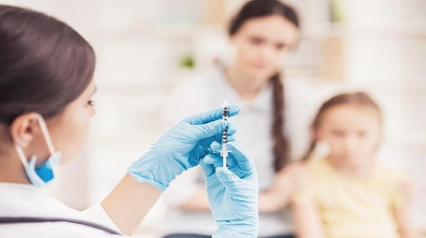 Doctor in Mask Prepare Vaccination for Little Girl. Medical Staff Concept. Doctor Pediatrician Concept. Visit to Doctor. Professional Family Doctor. Woman in Uniform Concept. Vaccination For Patient.