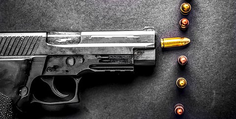 Bullets and handcuffs. Close-up of 9mm pistol. Gun and weapon with bullets amunition on black backround. Top view