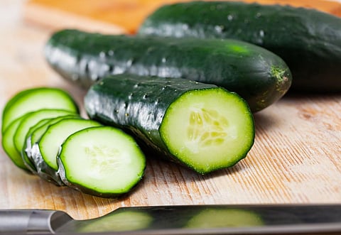 Primer plano de pepinos verdes frescos cortados sobre fondo de madera, nadie