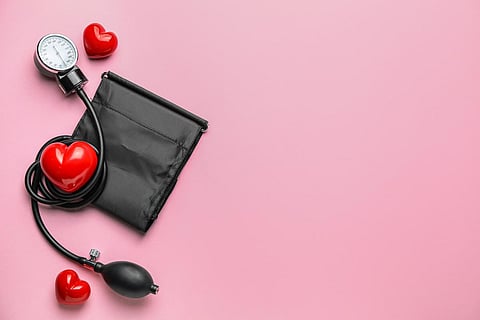 Sphygmomanometer with red hearts on color background