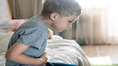 abdominal pain in a preschool child. poisoning in children. the boy holds his hands to the abdominal cavity