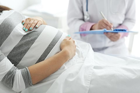 Young pregnant woman with doctor at the hospital