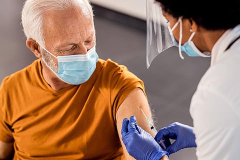 Male senior patient getting vaccinated at medical clinic during coronavirus pandemic. 