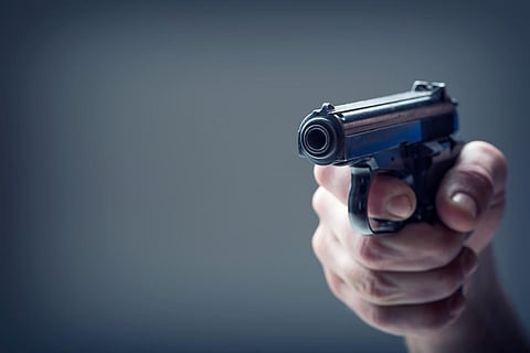 Arma de fuego. Mano de hombres sosteniendo un arma. Pistola de 9 mm.