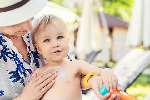 mother applying sunscreen to baby