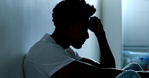 Person sitting on floor with mental illness