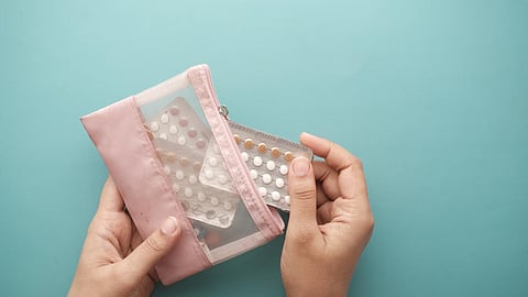 women hand holding birth control pills close up.