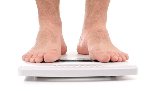 Diet concept. Man standing on weight scale