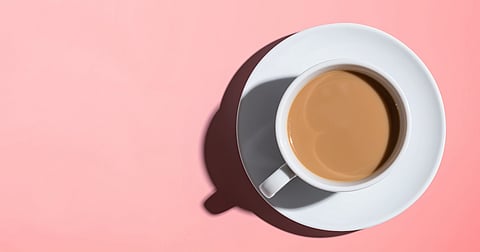 Photo of a cup of coffee on a salmon pink background