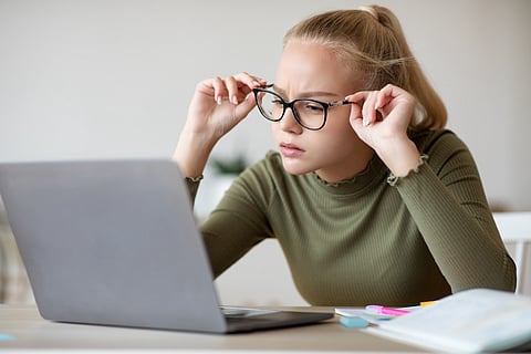 Adolescente en computadora portátil con anteojos 