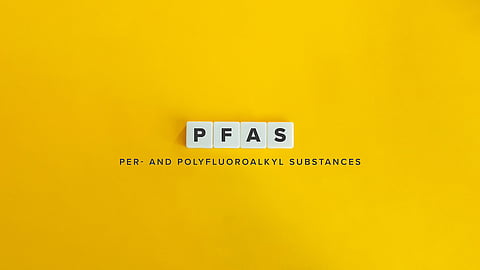 Photo of the acronym PFAS on dice against a yellow background