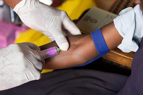 Photo of a Black doctor giving someone a shot in the arm