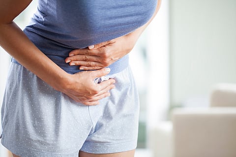 Photo of a person clutching their lower stomach/ovarian cancer