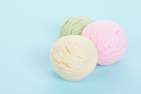 Closeup shot of various flavored delicious ice cream scoops isolated on blue background