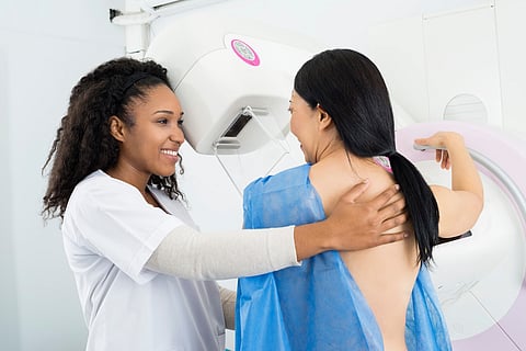 Happy Doctor Asistiendo a la Mujer que Se Somete a la Prueba de Rayos X de la Mamografía