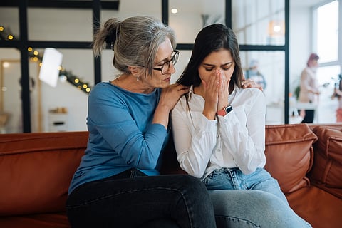 Grandmother comforting her sad granddaughter at home.