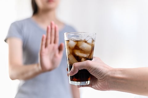 Dieting or good health concept. Young woman rejecting Junk food or unhealthy food such as sweet soda drink and choosing healthy food such as fresh fruit or vegetable.