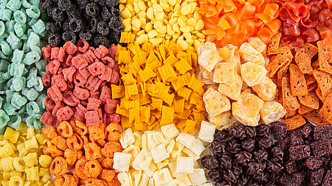 Coloridos alimentos procesados dispuestos sobre una superficie blanca, que muestran los hábitos dietéticos modernos y el impacto de la conveniencia en la nutrición y las opciones de estilo de vida.