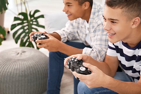 Adolescentes jugando videojuegos en casa