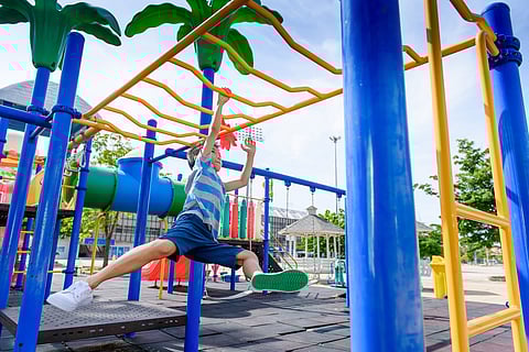 Young asian boy hang out door playground