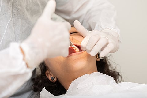 Young woman being seen in a dentist's office. Concept of toothache, wisdom tooth extraction, anesthesia, problems with caries or gums. Oral health care. Dentist day.