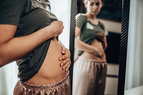 Pregnant women looking in mirror