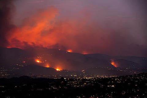 A nighttime wildfire tears through the hills of California.
