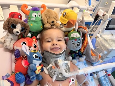 Oliver Staub, de 2 años, sonríe mientras se recupera de dos complejas cirugías de médula espinal en el Hospital Infantil Comer de UChicago Medicine que le volvieron a unir la cabeza a la médula espinal.
