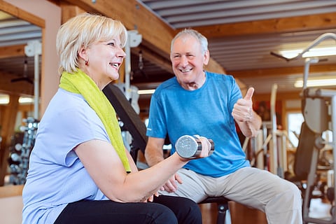 Senior woman in the gym exercising with dumbbells for fitness