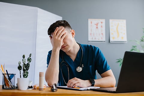 Stressed doctor feeling burnout in office